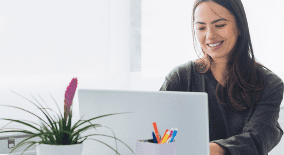 A woman looking at her computer screen feeling energetic with her strengths acting in the right way
