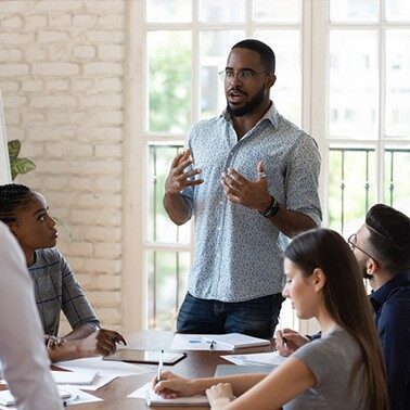 a black man giving a short speech on cliftonstrengths workshops and why they work