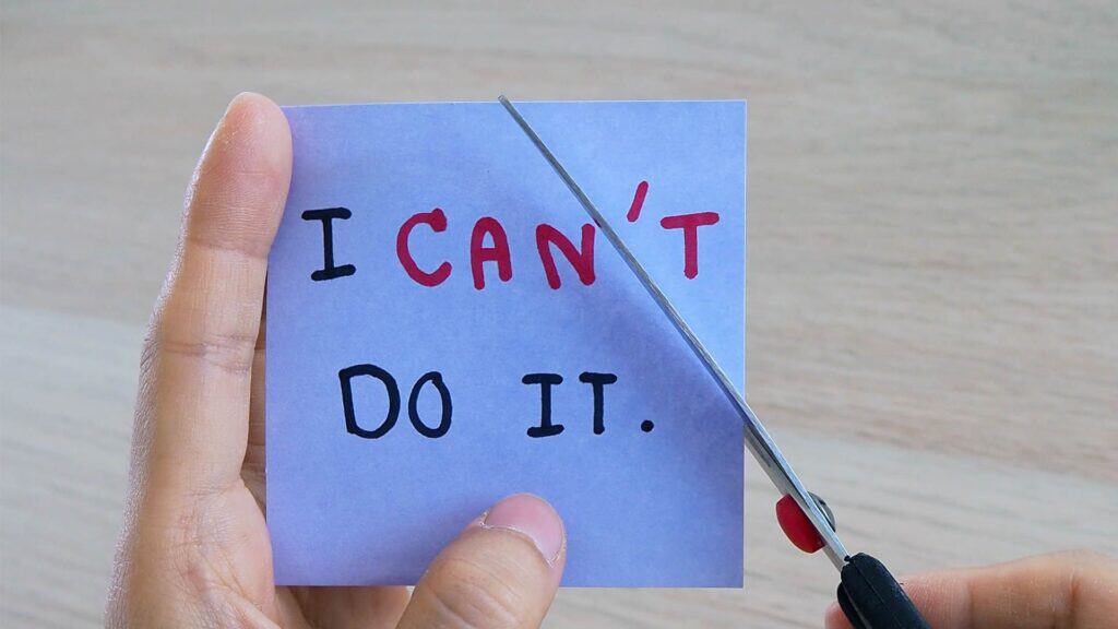 A scissor cutting out paper saying I can't do it to i can, thus the power of self-belief and self-confidence