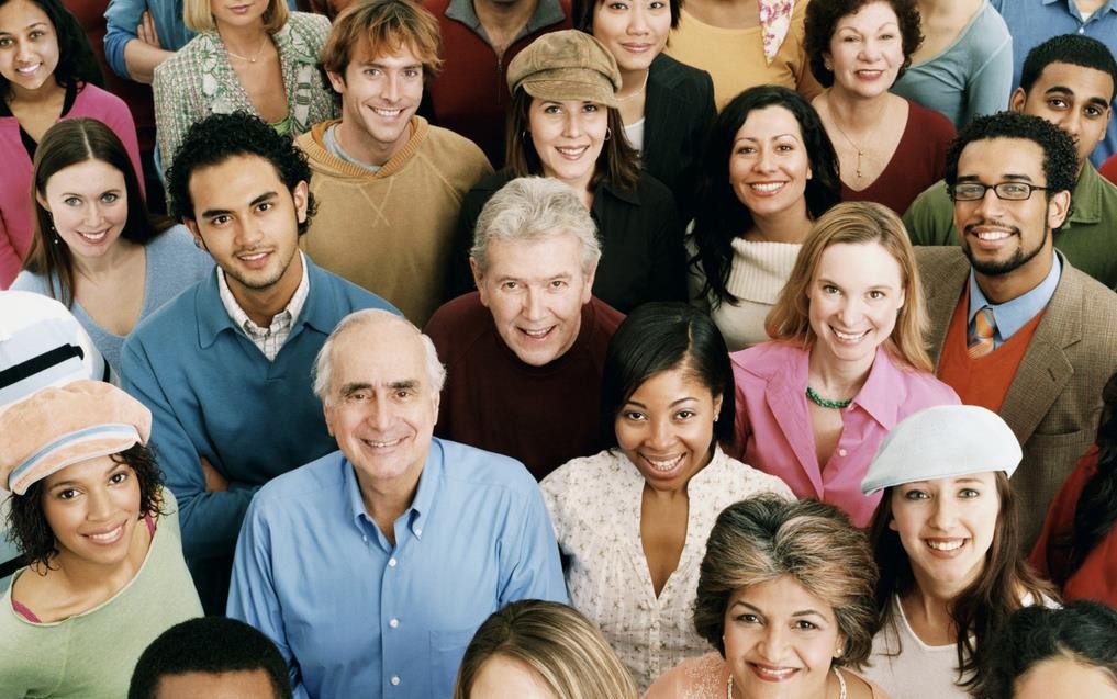 a diverse group of individuals with different ages working together in harmony, using gestures and body language to communicate effectively. Display them in a well-lit and inclusive workspace, with accessible technology and ergonomic furniture that caters to each individual's needs and abilities. Highlight the importance of mentorship and collaboration, with younger employees learning from the experience of their older colleagues while also sharing innovative ideas and perspectives.